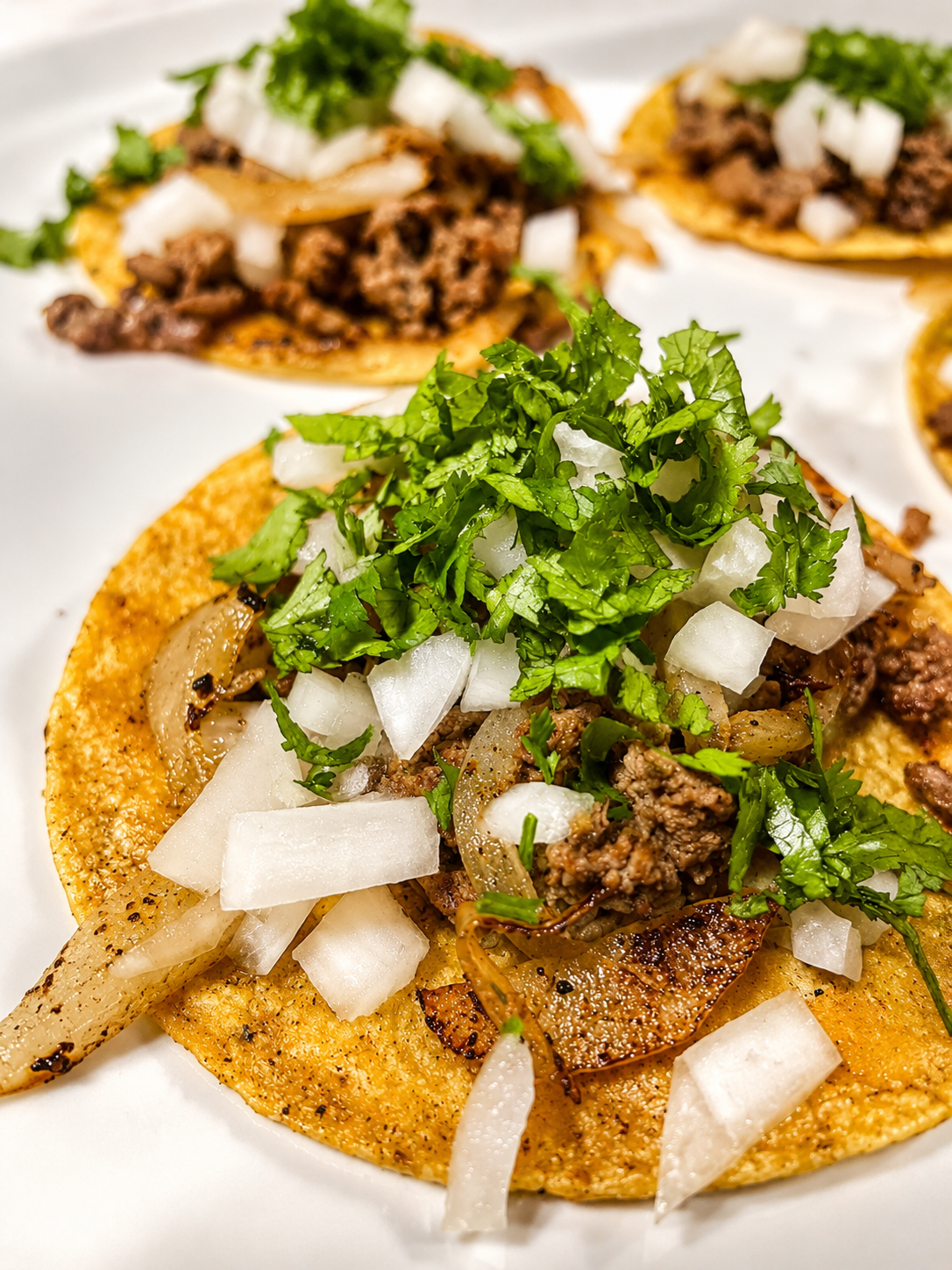 Mini street tacos topped with cilantro and onion
